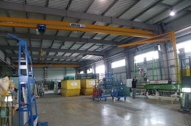 Single girder travelling cranes and pillar slewing jib cranes in production hall of the company Miroiterie Righetti in France