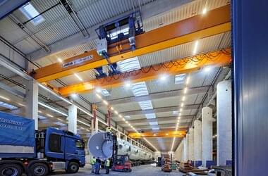 Double girder travelling cranes in tandem control unload pressure vessels from trucks