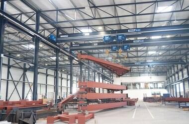 Single girder travelling cranes in tandem control system working in the field of truck loading in Spanish company