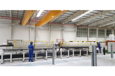 Employees use double-girder travelling crane in production hall of Corys Plastic Industries company
