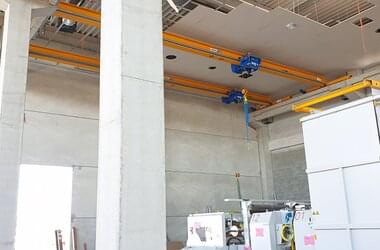 Single girder travelling cranes for transports through entire hall