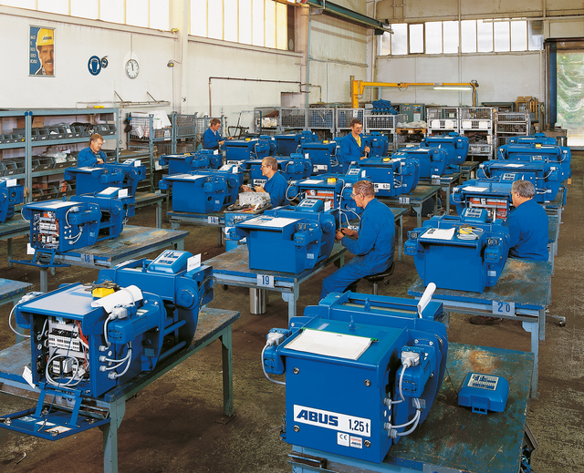 Employees work on final assembly of wire rope hoists of various types 