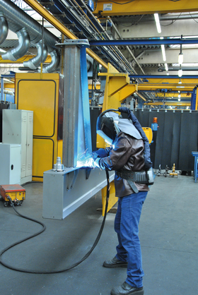 Welder welds crane boom horizontally through special rotating device to ensure ergonomic working positions
