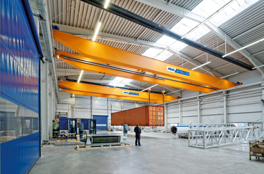 Double-girder overhead traveling cranes in synchronized operation at Neuero in Melle, Germany