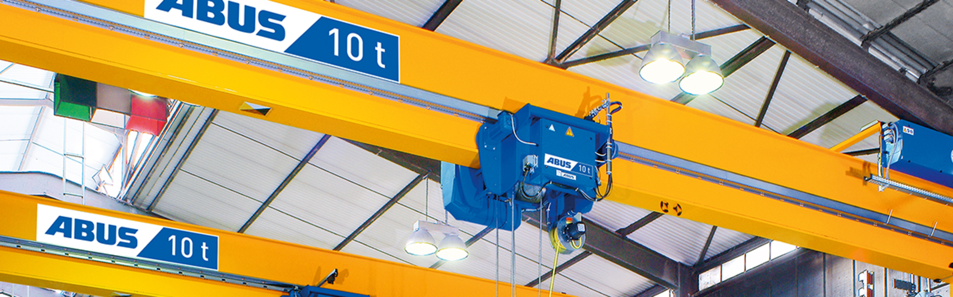 ABUS double-girder overhead crane with a wire rope hoist and a 10-ton lifting capacity in an industrial building.